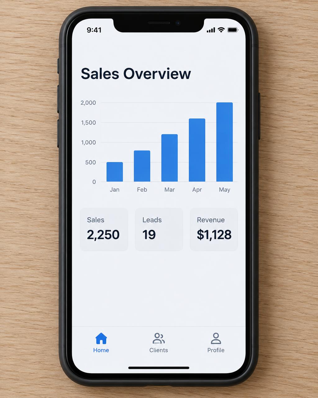 The finished app running on a phone on a desk: a clean sales dashboard with a bar chart
